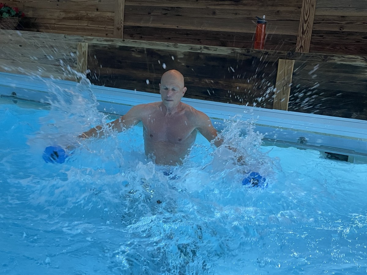 Teilnehmer beim Wassertraining mit blauen Aqua-Hanteln